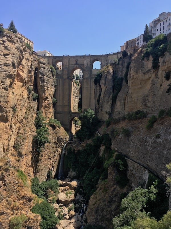 Spanish town of Ronda high on the cliffs, showing the bridge that traverses a 120m gorge joint the new & old parts of town.